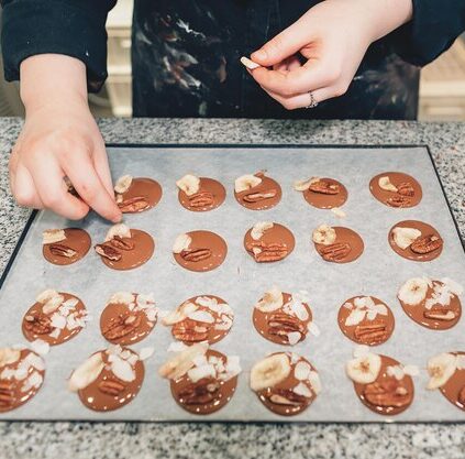 hands pastry chef who garnishes forms chocolate with nuts flavorings 573497 343